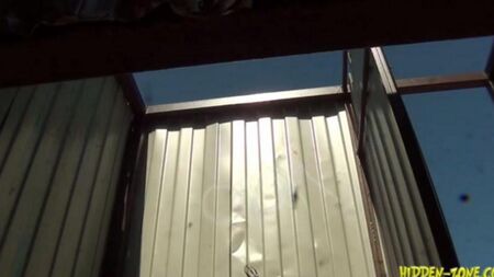 Скрытая камера снимает женщину в пляжной кабинке